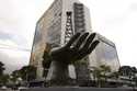 A sculpture of a hand holding an oil drilling rig stands outside the state-run oil company Petroleo…